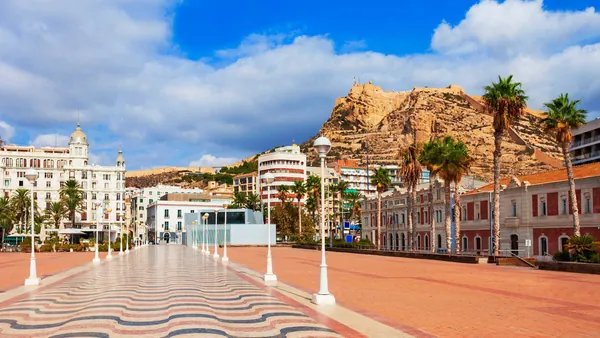 Explanada de España con mosaico ondulado y vista al castillo de Santa Bárbara en Alicante