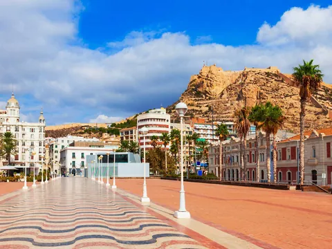 Explanada de España con mosaico ondulado y vista al castillo de Santa Bárbara en Alicante