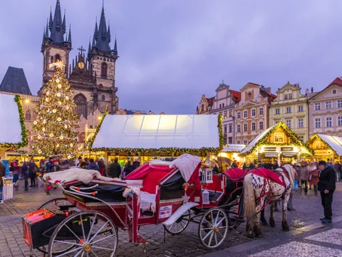 Mercado navideño en la Plaza de la Ciudad Vieja de Praga con carruaje y luces
