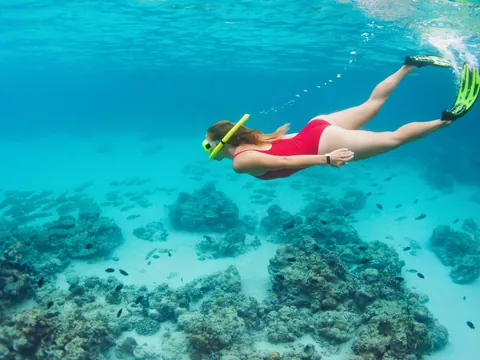 Mujer haciendo snorkel en las aguas de Mallorca entre arrecifes