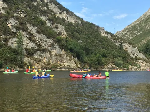 Grupo de piragüistas en canoas de colores por el río Sella, Asturias
