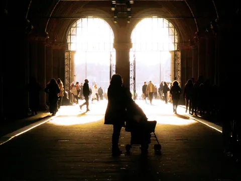 Personas caminando a contraluz por un pasaje iluminado en Ámsterdam