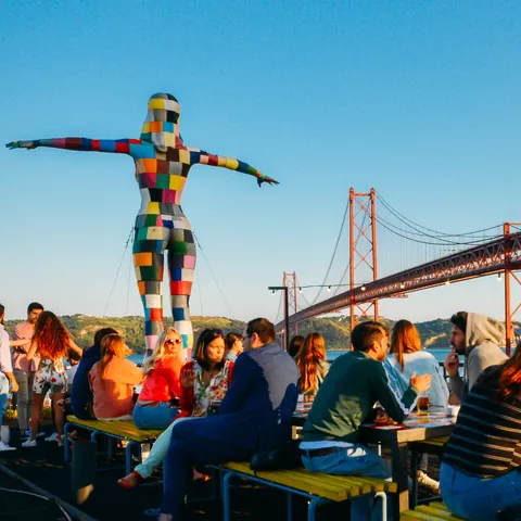 Vista del Puente 25 de Abril con gente en una terraza de la LX Factory de Lisboa - Alexandre Rotenberg / Shutterstock.com