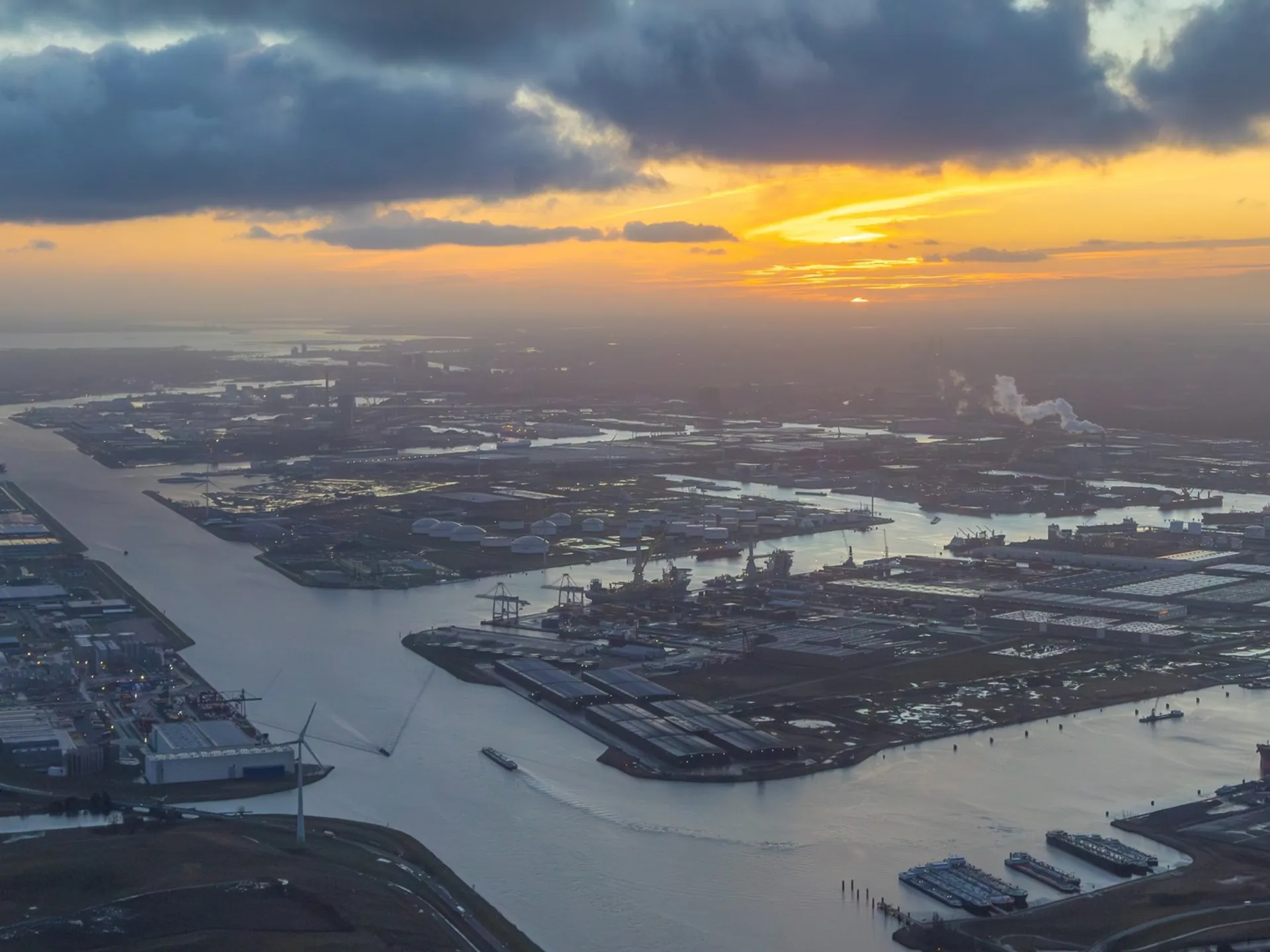Vista aérea del puerto de Ámsterdam con canales y barcos durante el atardecer.