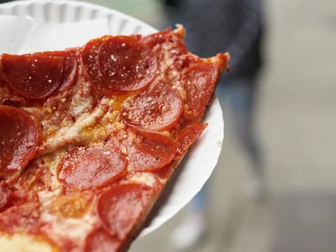 **Alt sugerido (≤80 caracteres):** Porción de pizza en un free tour gastronómico por Greenwich Village, Nueva York