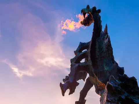 Escultura del dragón de Wawel lanzando fuego al atardecer en Cracovia, Polonia
