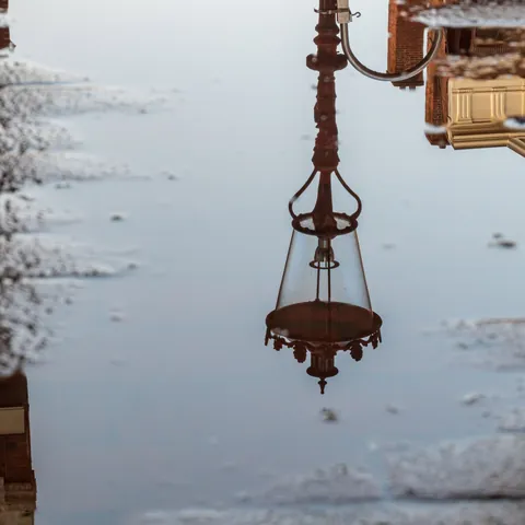 Reflejo de una farola en un charco en la calle de Ámsterdam