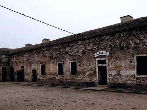 Patio de tierra con un edificio de ladrillo que dice BLOCK A en Terezín.