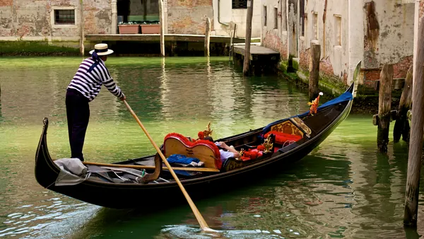 Góndola navegando por los canales de Venecia con gondolero guiando el paseo
