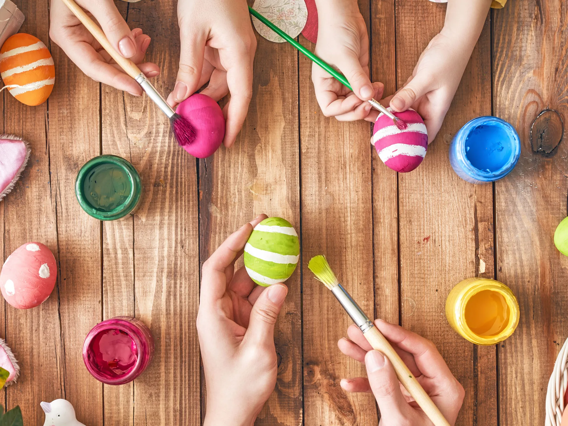 Padre, madre e hijo pintando huevos de pascua