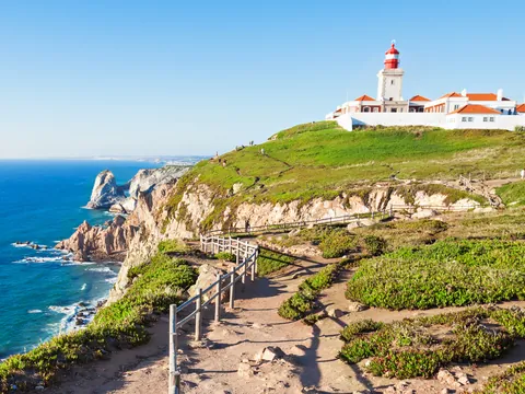 Acantilados del Cabo da Roca con su faro sobre el océano en un día despejado.