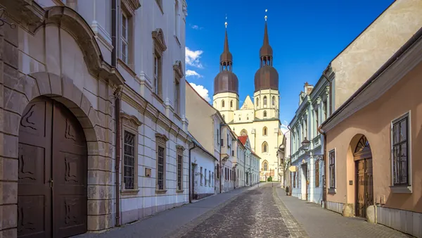 Basílica de San Nicolás desde una calle histórica en la ciudad de Trnava.