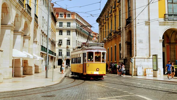 Tranvía circulando por una calle empedrada de Lisboa, Portugal