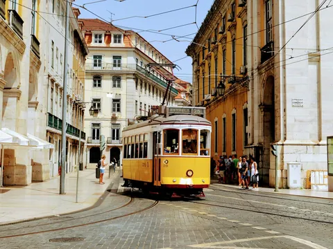 Tranvía circulando por una calle empedrada de Lisboa, Portugal