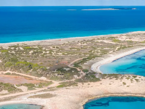 Playa de Formentera, aguas turquesas, arena blanca, veleros, yates, bañistas