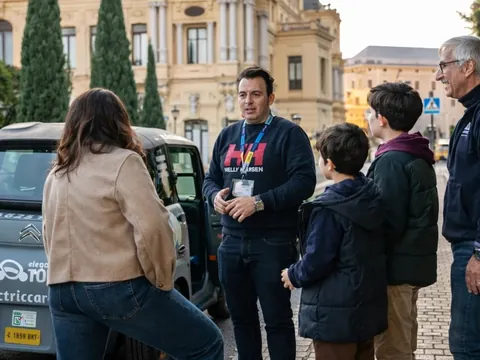 Guía explica tour a las cuevas del tesoro en coche eléctrico a una familia en Málaga, España.