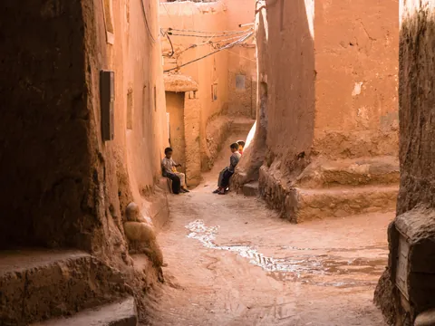 Calle tradicional de adobe en Ouarzazate con niños y arquitectura local