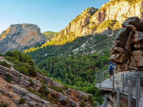 Senderistas por la pasarela de madera en el entorno natural del Caminito del Rey