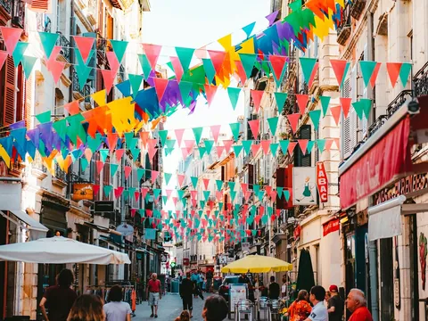 Calle de Bayona decorada con banderines de colores durante ambiente festivo.
