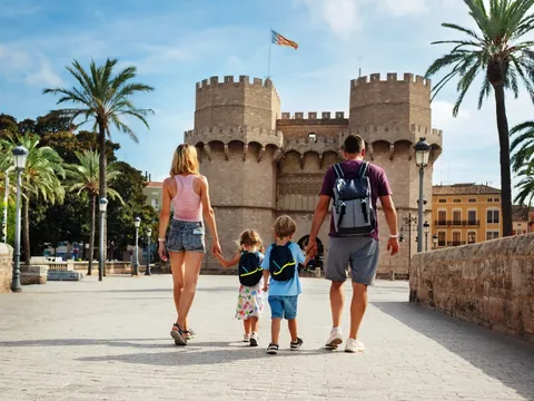 Familia caminando de la mano hacia las Torres de Serranos en Valencia