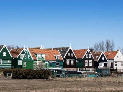 Casas tradicionales de Marken con fachadas de madera junto al campo.