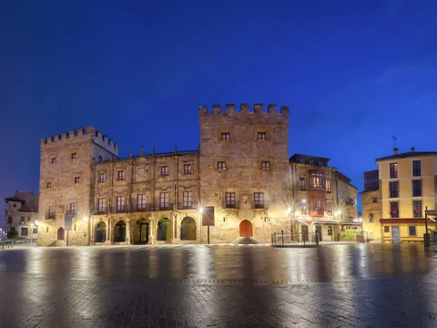 Palacio de Revillagigedo al anochecer, iluminado frente a la plaza en el casco histórico de Gijón, Asturias