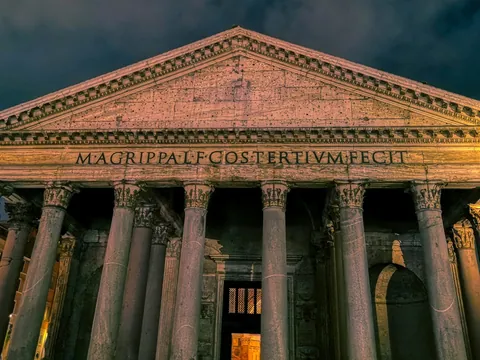 Panteón de Roma iluminado de noche con su fachada clásica y columnas frontales