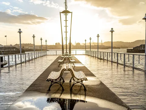 Paseo marítimo de Gijón al atardecer, con farolas y vistas al mar Cantábrico, Asturias, España