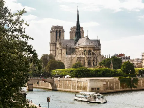 Un bote se desplaza por el río junto al imponente edificio de Notre Dame.