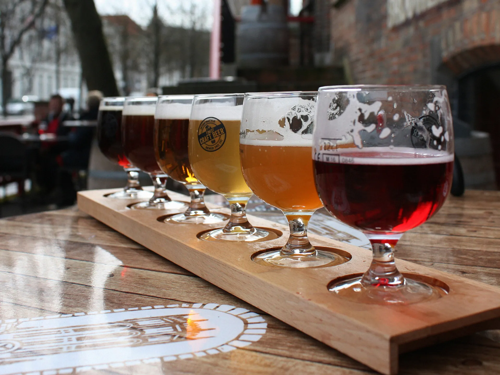 Cata de seis cervezas artesanales en tabla sobre terraza urbana en Bélgica