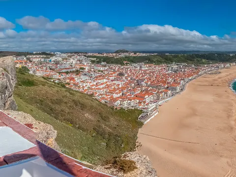 Panorámica de Nazaré con su amplia playa y casas junto al acantilado.