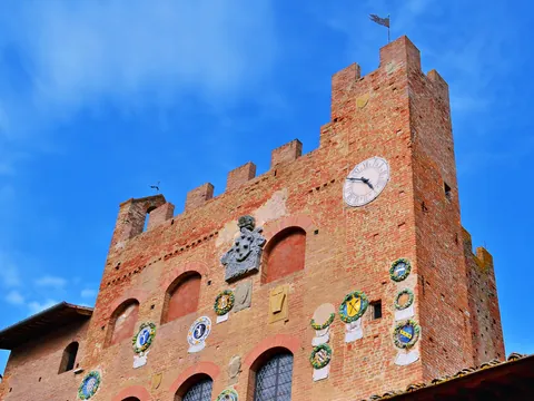Torre medieval con escudos heráldicos en un pueblo de la Toscana, Italia