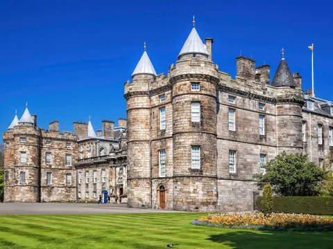 Fachada principal del Palacio de Holyroodhouse en Edimburgo bajo un cielo azul despejado