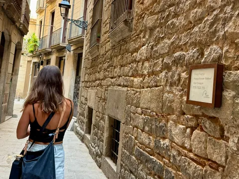 Mujer caminando frente a la Sinagoga Mayor en el Call de Barcelona
