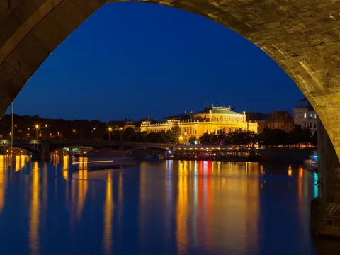 Vista nocturna del Rudolfinum desde un arco del puente en Praga, República Checa