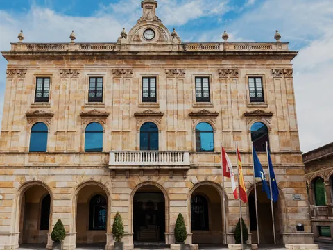 Fachada principal del Ayuntamiento de Gijón, edificio histórico con arcos y balcones en la Plaza Mayor de la ciudad