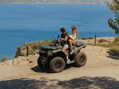 Pareja en quad parada frente al mar. contemplando el paisaje.