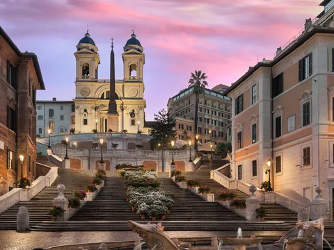 Escalinata de la Plaza de España y la iglesia Trinità dei Monti al ocaso en Roma.