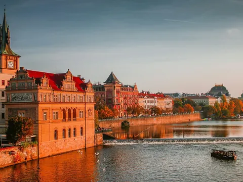 Edificios históricos a orillas del río Moldava al atardecer en Praga.