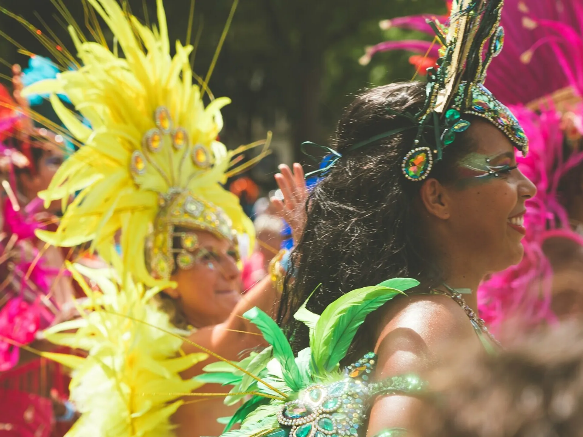 Bailarinas con trajes de plumas coloridas desfilando en el Carnaval de Sitges