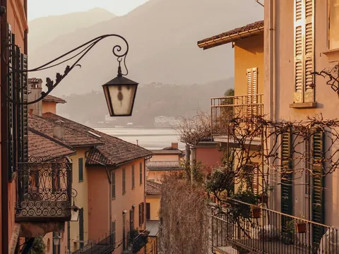 Calle con vista al Lago di Como al atardecer entre fachadas históricas