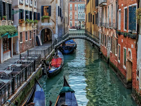 Góndolas atracadas en un canal estrecho del centro histórico de Venecia