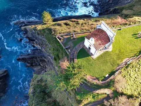 Vista aérea de la Ermita de la Guía sobre el acantilado junto al mar en Llanes