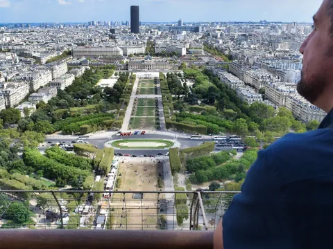 Hombre observando el Campo de Marte desde la Torre Eiffel en París