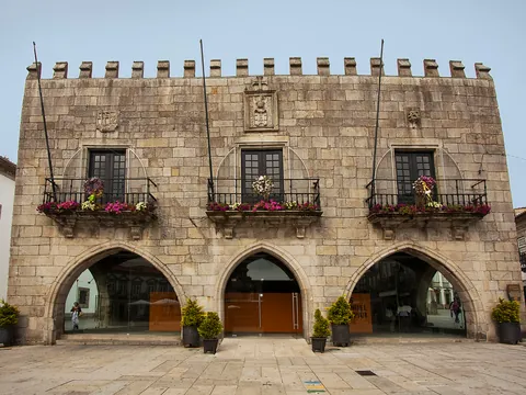 Fachada del antiguo ayuntamiento de Viana do Castelo con arcos y balcones floridos.