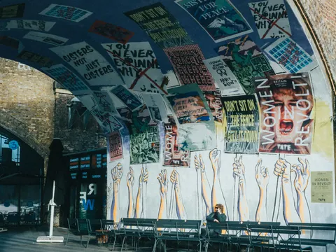 Pasadizo de Camden Town con arte urbano, carteles activistas y atmósfera bohemia alternativa
