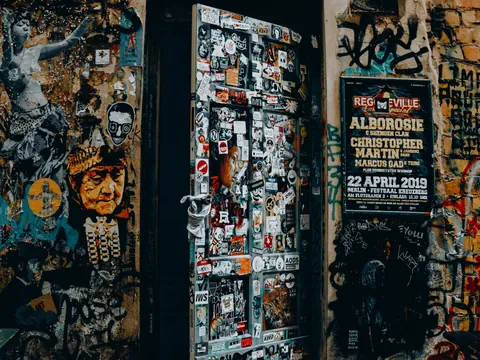 Puerta y paredes repletas de grafitis y pegatinas en Dead Chicken Alley, Berlín