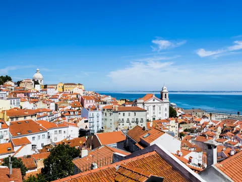 Panorámica del mirador de Santa Lucía con Alfama y el río Tajo bajo un cielo despejado.