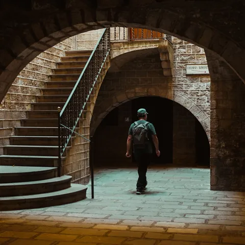 Hombre caminando por patio de piedra en el Barrio Gótico