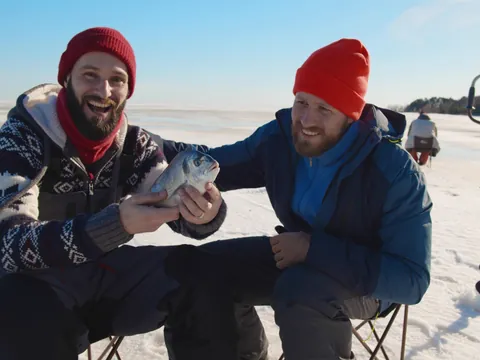 Roveniemi durante el invierno, personas disfrutando de la pesca en hielo sobre un lago congelado.